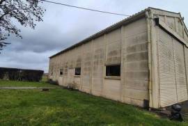 Hangar de 200 m² accessible PL, parking macadam, bâti sur 722 m² clos et constructibles.